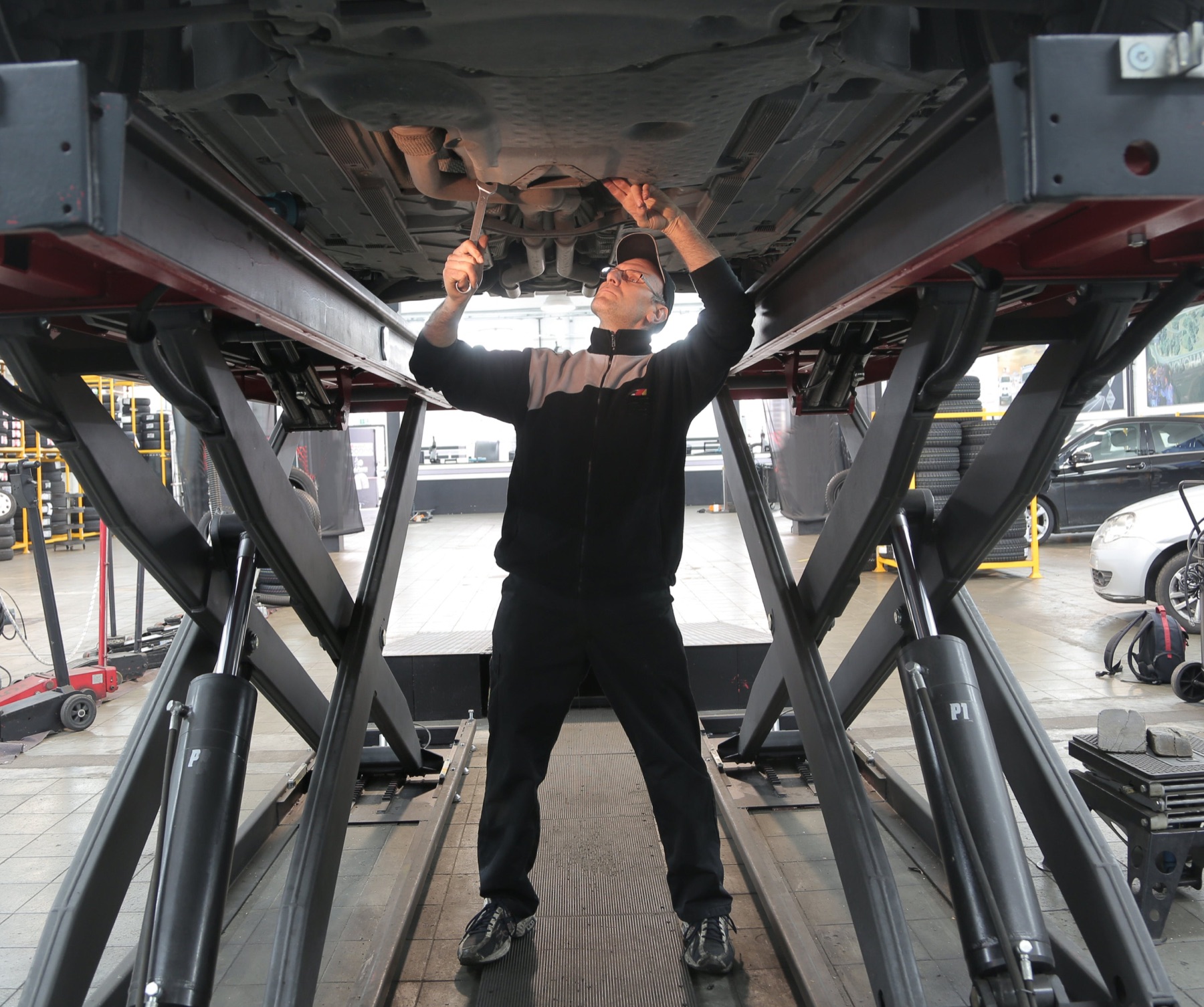 Schrauber bei der Arbeit unter einem Fahrzeug in der Schruberei
